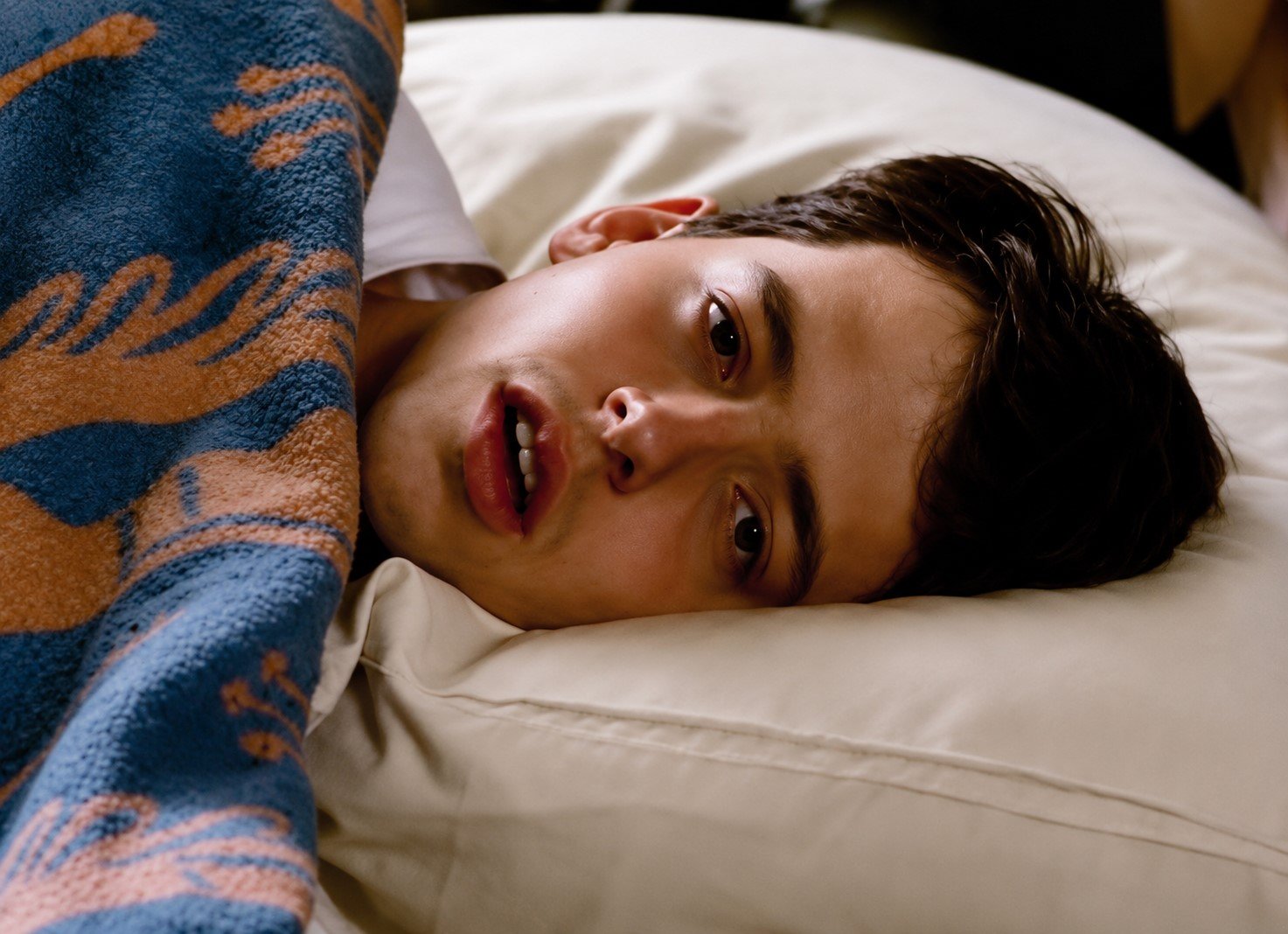 A boy lying in bed, looking ill